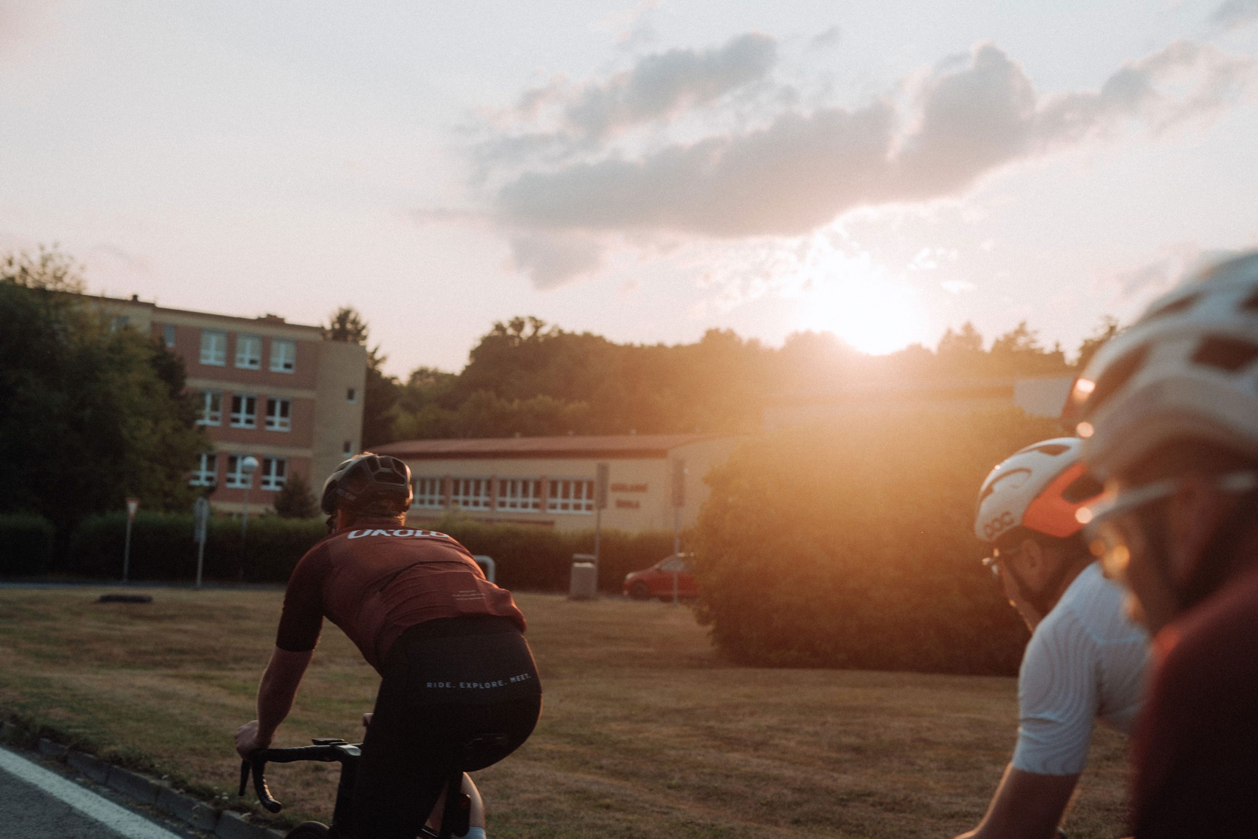 Road cyclists in an urban landscape at sunset, riding through the city.