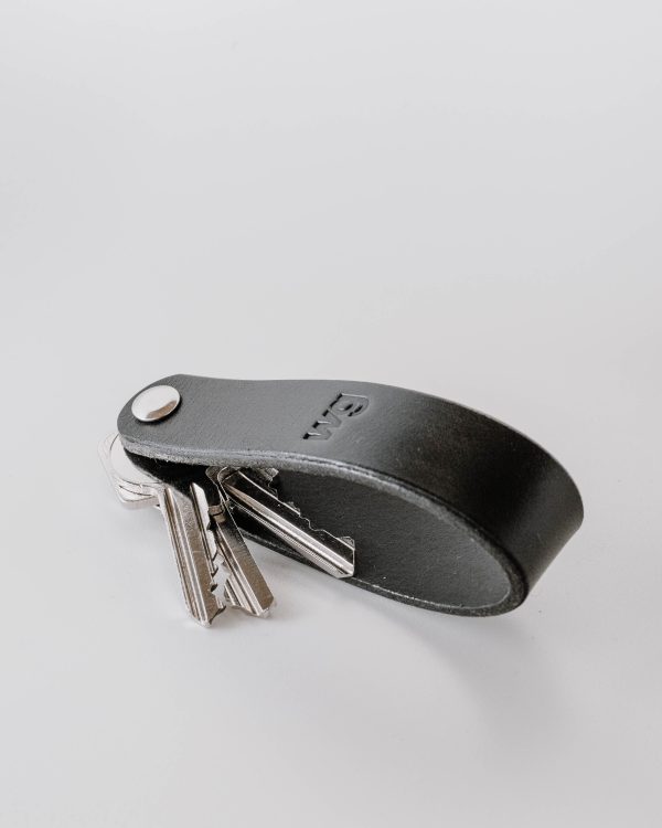 Side view of the key chain from watts and grams with three keys.