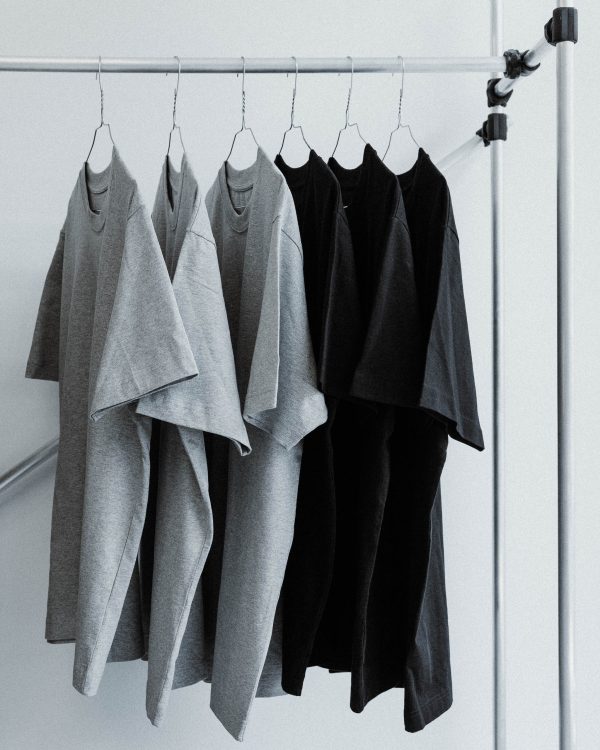 Gray and black watts and grams logo t-shirt unisex hung on a clothes rail.
