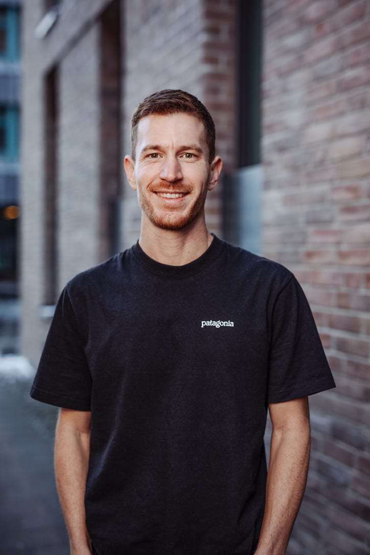Basti, founder of watts and grams — portrait in front of a brick wall